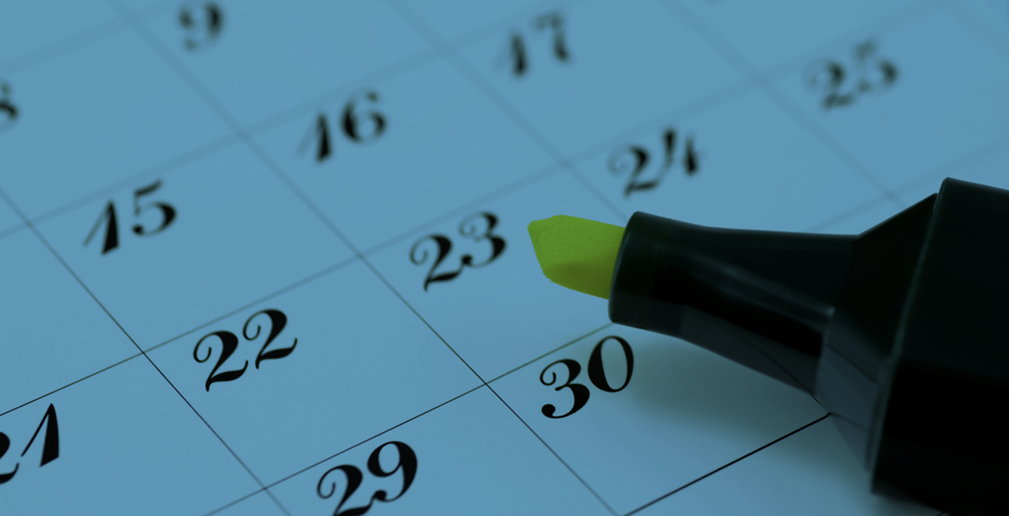 Close-up of a calendar with a date highlighted using a yellow marker, representing the scheduling of upcoming Vistage leadership events and conferences.
